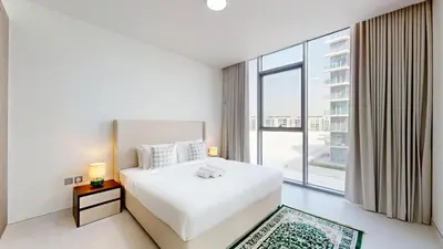 a bedroom with a white bed and a large window at Vacationer l Serene 3 Bed Haven l Private Beach l District One in Dubai