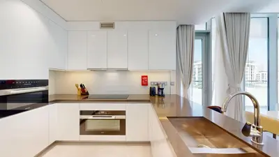 a kitchen with white cabinets and a sink at Vacationer l Serene 3 Bed Haven l Private Beach l District One in Dubai