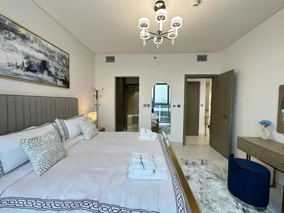 a bedroom with a large white bed and a desk at Vacationer l Stunning 1 Bed l Private Beach l near Downtown in Dubai