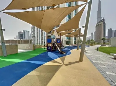 a playground with a slide and umbrellas on a building at Vacationer I Luxury 3 Bedroom Apartment I Iconic Burj Khalifa View I Heart of Downtown in Dubai