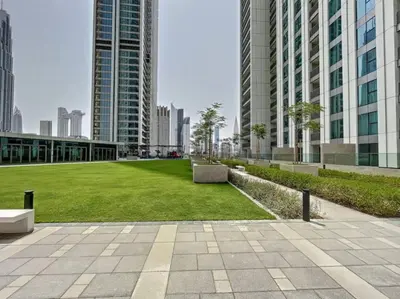 a park in the middle of a city with tall buildings at Vacationer I Luxury 3 Bedroom Apartment I Iconic Burj Khalifa View I Heart of Downtown in Dubai