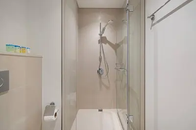 a bathroom with a shower with a glass door at Luxury 2 bedroom with Burj Khalifa view, connected to Dubai Mall in Dubai