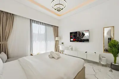 a white bedroom with a large bed and a window at Estudio Rimal en Dubái por beBalmy in Dubai