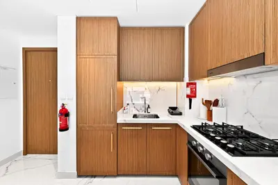 a kitchen with wooden cabinets and a stove top oven at Apartamento Dune en Dubái por beBalmy in Dubai