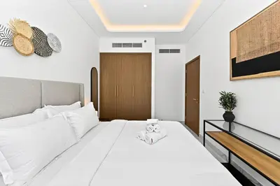 a bedroom with a large white bed with white sheets at Apartamento Dune en Dubái por beBalmy in Dubai