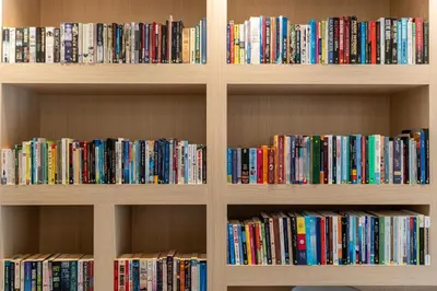 a book shelf filled with lots of books at Palmoral Collection Stunning Studio with Dining Area in Dubai