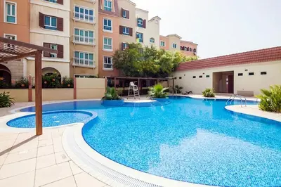 a large swimming pool in front of a building at Palmoral Collection Stunning Studio with Dining Area in Dubai