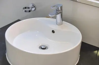 a white sink in a bathroom with aaucet at Burj Khalifa view - 2 BR apartment in Downtown in Sabkhah