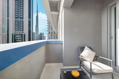 a balcony with a chair and a window with a view at Burj Khalifa view - 2 BR apartment in Downtown in Sabkhah