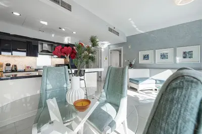 a kitchen and dining room with a glass table and chairs at Burj Khalifa view - 2 BR apartment in Downtown in Sabkhah