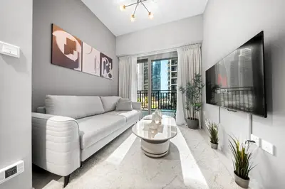 a living room with a white couch and a tv at Stylish & Elegant Stay Prime Business Bay Spot in Dubai