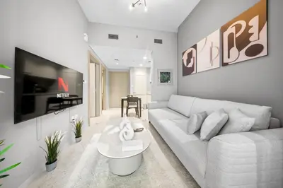a living room with a white couch and a tv at Stylish & Elegant Stay Prime Business Bay Spot in Dubai