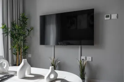 a living room with a tv on a wall with vases at Stylish & Elegant Stay Prime Business Bay Spot in Dubai
