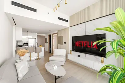 a living room with a television on a wall at VayK - Gorgeous 1BR Retreat in Binghatti Corner in Dubai