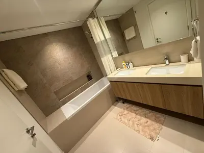 a bathroom with a sink and a tub and a mirror at Luxury Apartment Downtown views 2 in Dubai