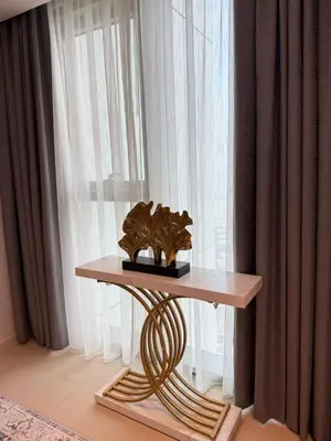 a table with a sculpture on it in front of a window at Luxury Apartment Downtown views 2 in Dubai