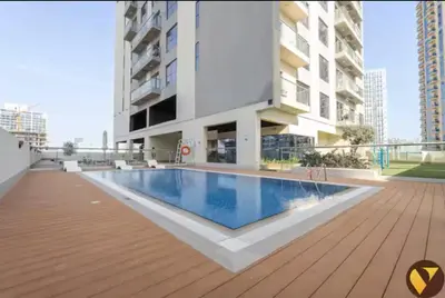 a swimming pool in the middle of a building at Vogue JVC Jeewar Tower near Circle Mall, One Bedroom Apartment with Balcony and Park view, Access to all Amenities in Dubai