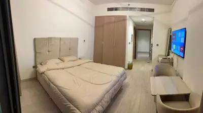 a bedroom with a large bed and a table at Deluxe studio water front in Dubai
