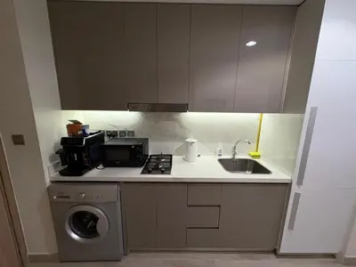 a kitchen with a sink and a washing machine at Deluxe studio water front in Dubai