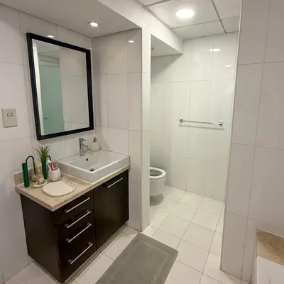 a bathroom with a sink and a toilet and a mirror at Luxury Family Friendly Apartment - Full Burj Khalifa & Fountain Views in Dubai