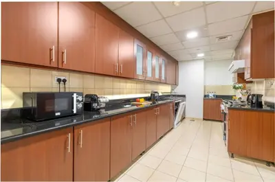 a large kitchen with wooden cabinets and appliances at JBR Saddaf 4 By Luxe Living - Marina & Sea Views in Dubai