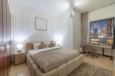 a bedroom with a bed and a desk and a window at JBR Saddaf 4 By Luxe Living - Marina & Sea Views in Dubai
