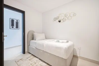 a white bedroom with a bed and a window at Downtown Views By Luxe Living - Full Burj Khalifa Views in Dubai