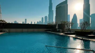 a swimming pool on top of a building with a city skyline at Downtown Views By Luxe Living - Full Burj Khalifa Views in Dubai
