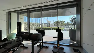 a room with a gym with a large window at Downtown Views By Luxe Living - Full Burj Khalifa Views in Dubai