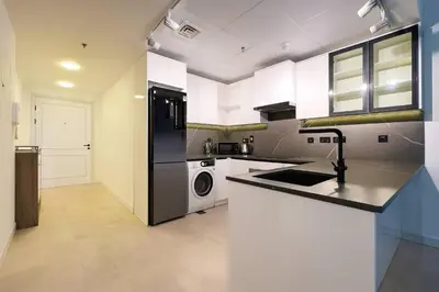 a kitchen with a black refrigerator and a dishwasher at Modern & Cozy 1BR Apartment | Dubai Eye View in Dubai
