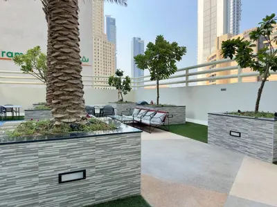 a courtyard with palm trees and chairs in a city at Modern & Cozy 1BR Apartment | Dubai Eye View in Dubai