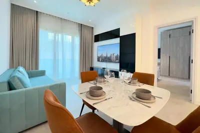 a dining room and living room with a table and chairs at Modern & Cozy 1BR Apartment | Dubai Eye View in Dubai