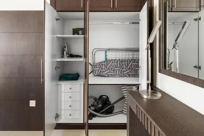a walk in closet with white shelves and a mirror at Serene 1BR with Balcony & Pool in Siraj Tower in Dubai