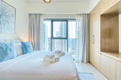 a bedroom with a large bed with towels on it at PVH - Charming 1BR near Dubai Mall - Burj Royale in Dubai