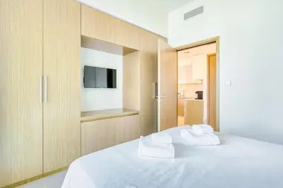 a bedroom with a white bed with two towels at PVH - Charming 1BR near Dubai Mall - Burj Royale in Dubai