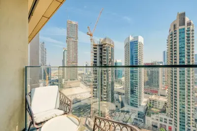a balcony with a chair and a view of a city at PVH - Charming 1BR near Dubai Mall - Burj Royale in Dubai