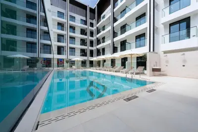a swimming pool in an apartment complex with a building at Contemporary Luxe Stay at Dawn by Binghatti! in Dubai