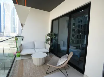 a living room with a couch and a table and chairs at Flat in Downtown, Pool & Canal view in Dubai