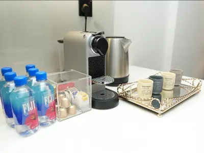 a counter with a coffee maker and bottles and cups at Flat in Downtown, Pool & Canal view in Dubai