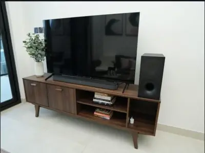 a flat screen tv sitting on top of a wooden entertainment center at Flat in Downtown, Pool & Canal view in Dubai