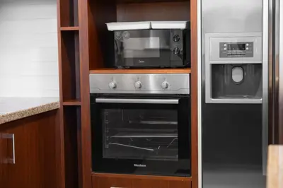a kitchen with a microwave and a stove at Luxury 4 BR with full Burj Khalifa and Fountain View - Connected to Dubai Mall and Metro Station in Dubai