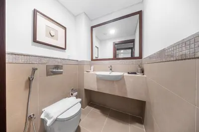 a bathroom with a toilet and a sink and a mirror at Luxury 4 BR with full Burj Khalifa and Fountain View - Connected to Dubai Mall and Metro Station in Dubai