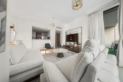 a living room with a couch and a tv at Luxury 4 BR with full Burj Khalifa and Fountain View - Connected to Dubai Mall and Metro Station in Dubai