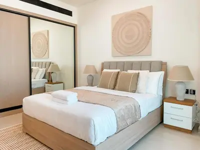 a bedroom with a large bed and a mirror at Amberwood 2BR Haven at Dawn by Binghatti JVC in Dubai