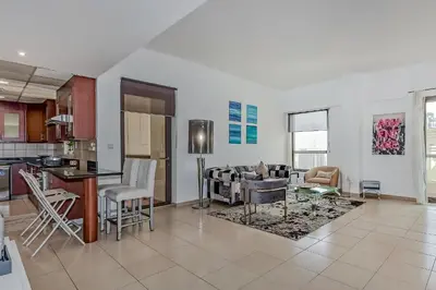 a kitchen and living room with a table and chairs at Marina View Relax - Sadaf 1BR Apartment in Dubai