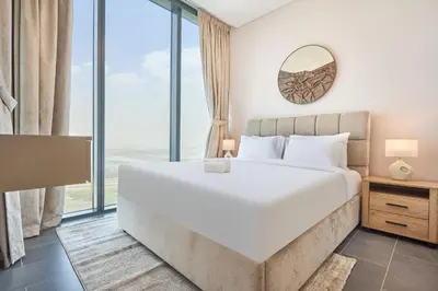 a bedroom with a large bed and large windows at STAY BY LATINEM Luxury 1BR Plus Study Holiday Home CB 1808 Near Burj Khalifa in Dubai