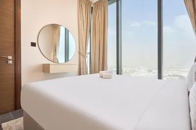 a bedroom with a large white bed and a mirror at STAY BY LATINEM Luxury 1BR Plus Study Holiday Home CB 1808 Near Burj Khalifa in Dubai