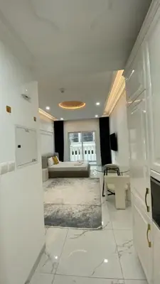 a white living room with a couch and a table at Boutique Studio Elegant Stay in Arjan Dubai in Dubai