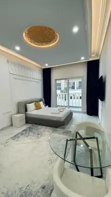 a living room with a bed and a glass table at Boutique Studio Elegant Stay in Arjan Dubai in Dubai