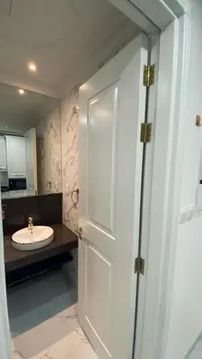 a bathroom with a white door and a sink at Boutique Studio Elegant Stay in Arjan Dubai in Dubai